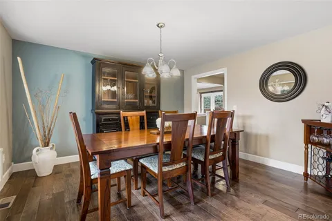 a dining room with furniture a chandelier and wooden floor