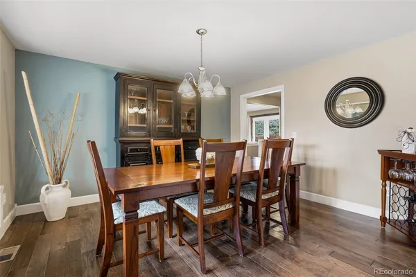 a dining room with furniture a chandelier and wooden floor