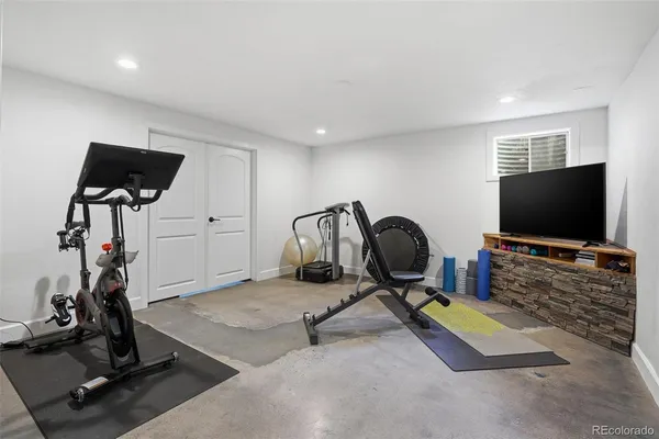 a room with gym equipment and a flat screen tv
