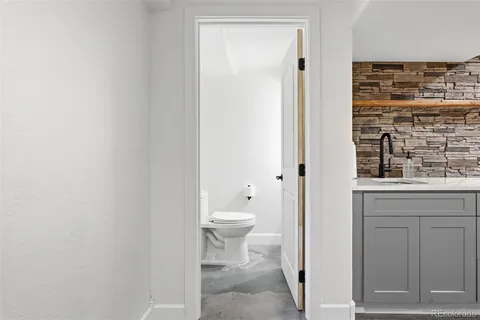 a bathroom with a granite countertop toilet and a sink