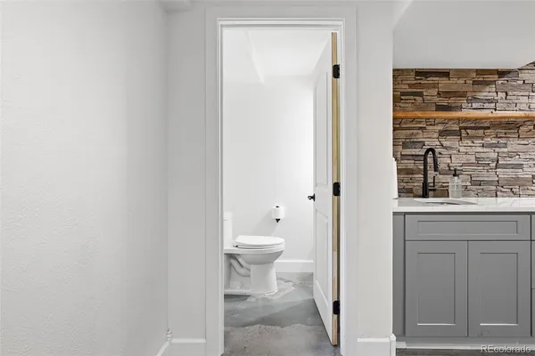 a bathroom with a granite countertop toilet and a sink