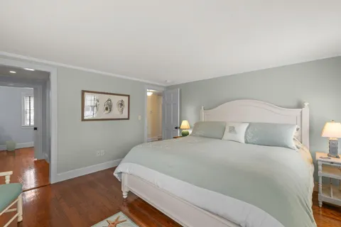 a bedroom with a bed a chair and next to a window