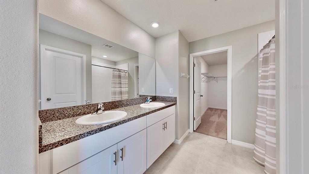 3059 Nubbin Ridge Lane Zephyrhills, FL 33540 - Photo 15 of 22 a en suite bathroom with a granite countertop sink and mirror