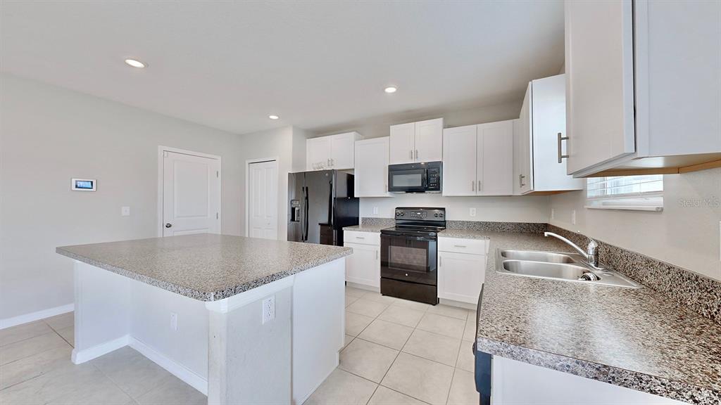 3059 Nubbin Ridge Lane Zephyrhills, FL 33540 - Photo 2 of 22 a kitchen with stainless steel appliances granite countertop a sink a stove and a refrigerator