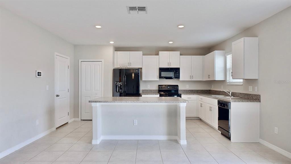 3059 Nubbin Ridge Lane Zephyrhills, FL 33540 - Photo 4 of 22 a kitchen with stainless steel appliances a refrigerator sink and stove