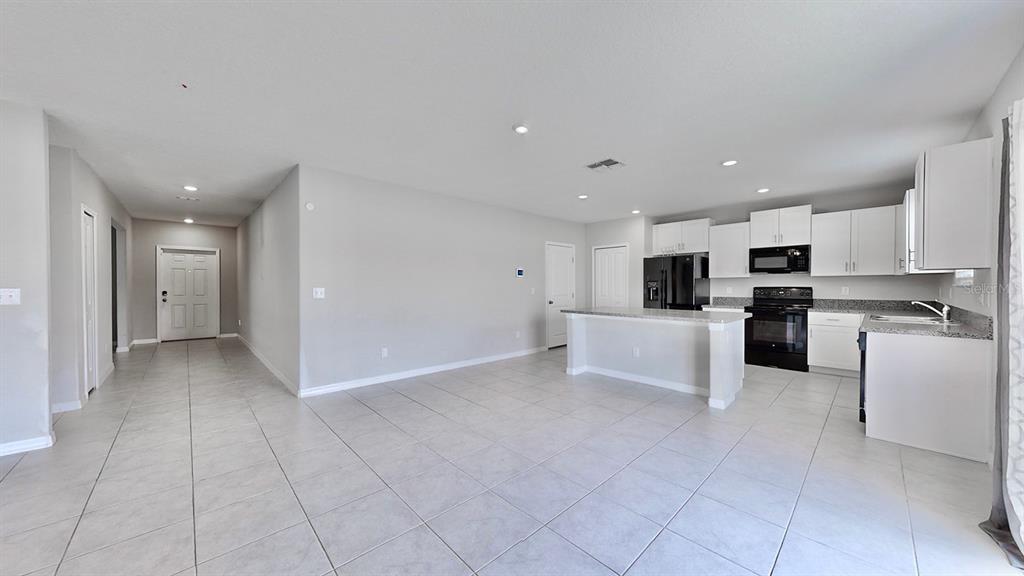 3059 Nubbin Ridge Lane Zephyrhills, FL 33540 - Photo 5 of 22 a view of kitchen with refrigerator and cabinets