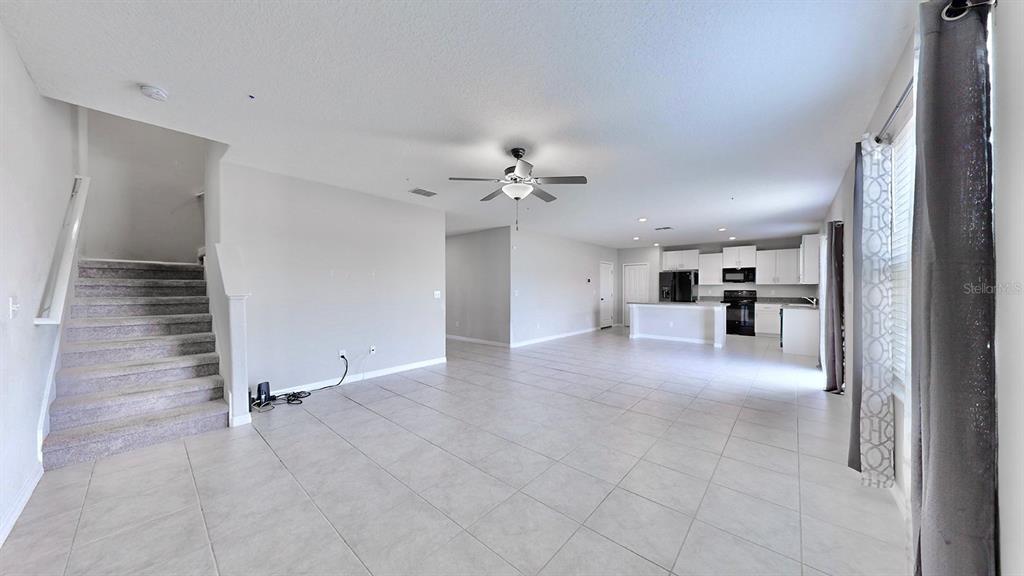 3059 Nubbin Ridge Lane Zephyrhills, FL 33540 - Photo 7 of 22 a view of a kitchen with a sink and a refrigerator a fireplace