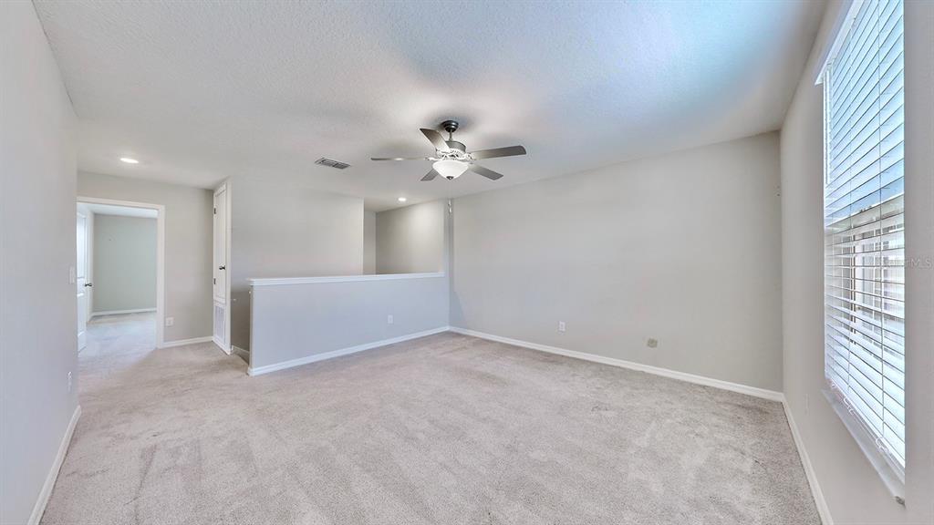 3059 Nubbin Ridge Lane Zephyrhills, FL 33540 - Photo 8 of 22 a view of a big room with windows and chandelier fan