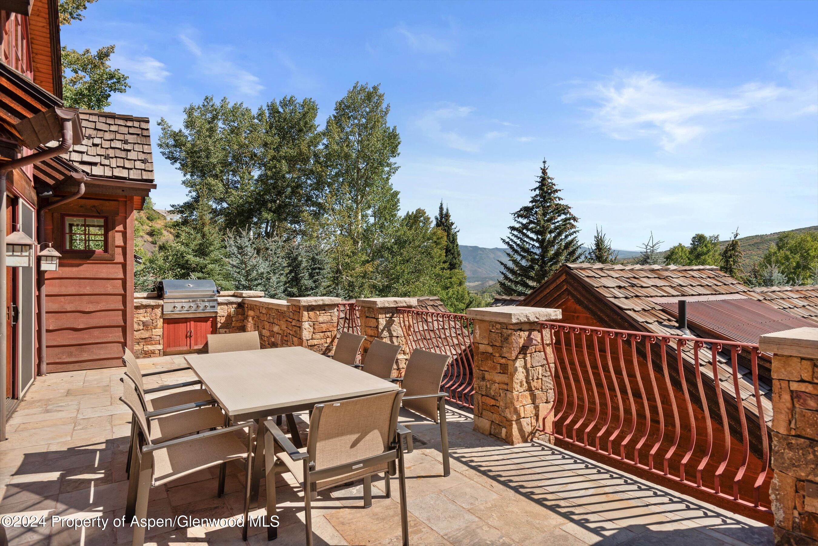 71 Meadow Road Snowmass Village, CO 81615 - Photo 11 of 48 a balcony of a house with wooden floor outdoor seating and barbeque oven