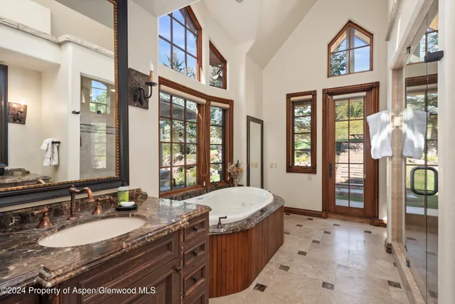 a spacious bathroom with a granite countertop tub and a large mirror