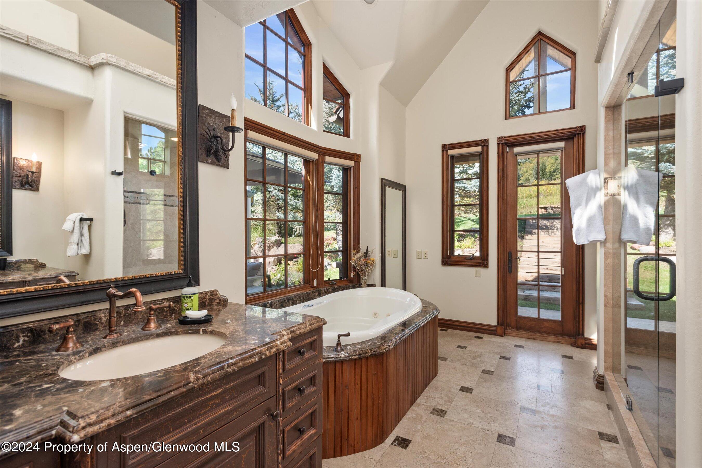 71 Meadow Road Snowmass Village, CO 81615 - Photo 14 of 48 a spacious bathroom with a granite countertop tub and a large mirror