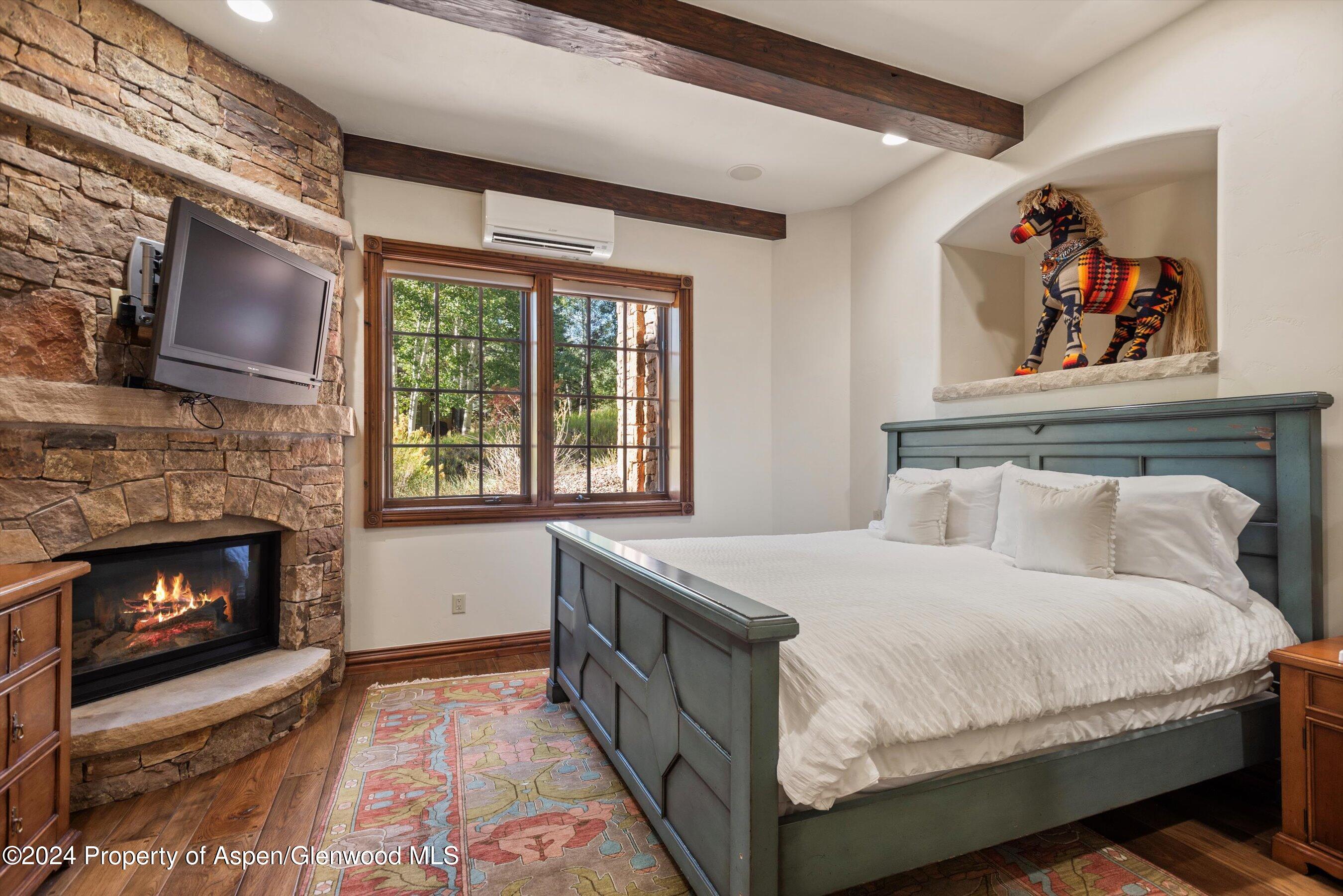71 Meadow Road Snowmass Village, CO 81615 - Photo 20 of 48 a bedroom with a bed and a fireplace