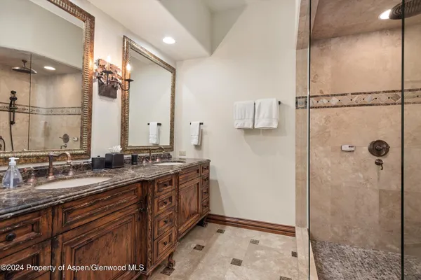a bathroom with a double vanity sink mirror and shower