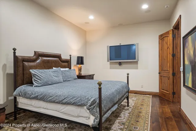 a bedroom with a bed and a flat screen television