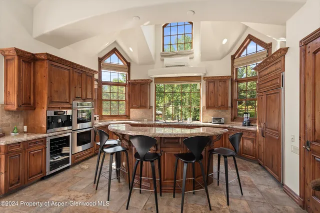 a kitchen with stainless steel appliances a table and chairs in it
