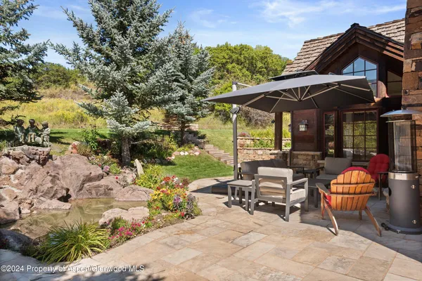 a view of a patio with table and chairs under an umbrella