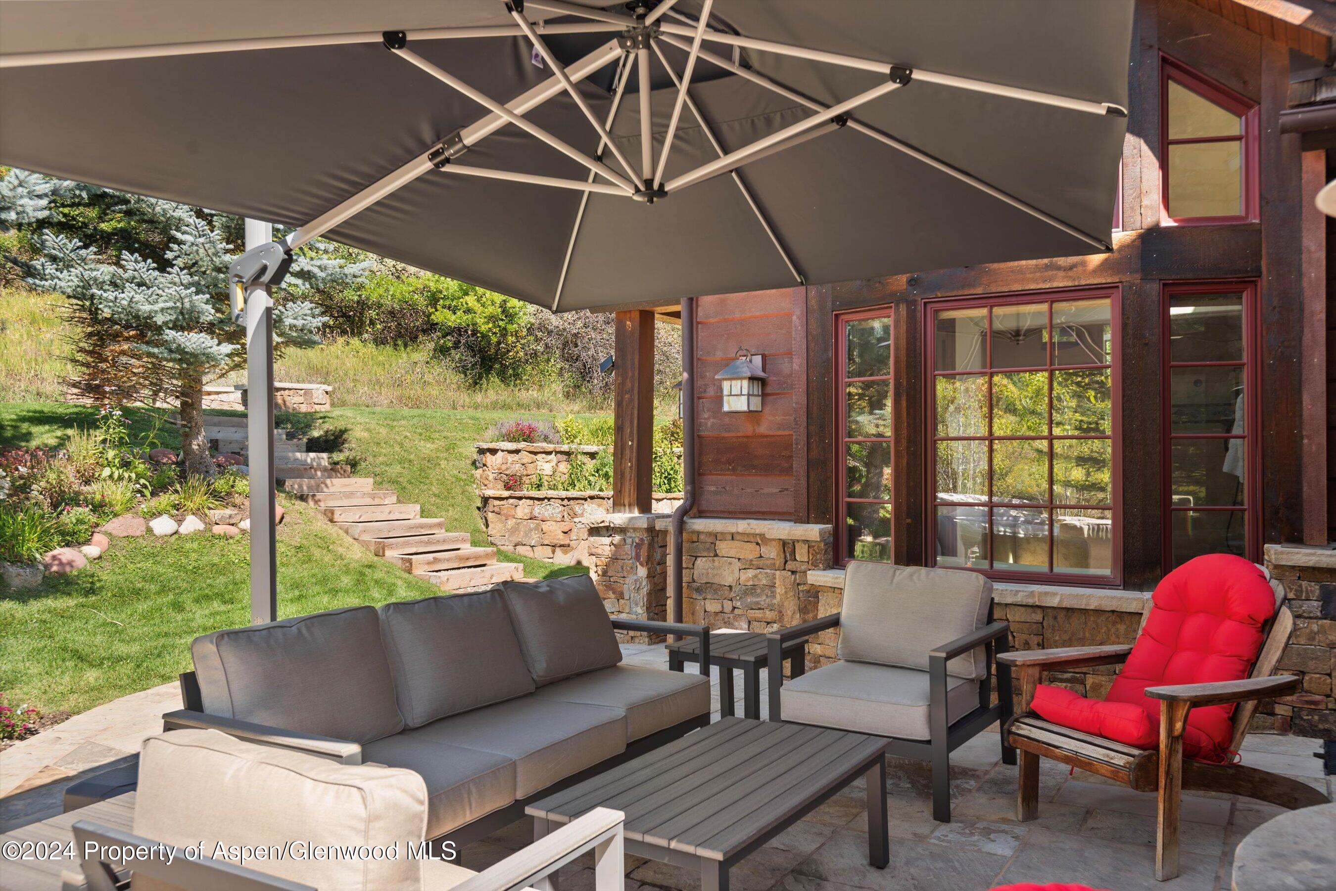 71 Meadow Road Snowmass Village, CO 81615 - Photo 35 of 48 a outdoor sitting area with furniture and a umbrella
