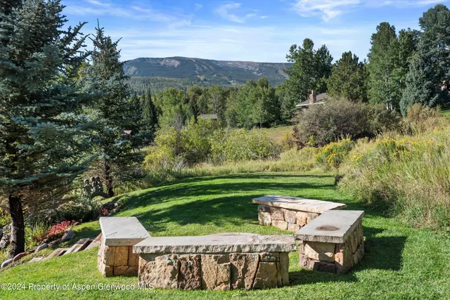 a view of a chairs and table on the green field