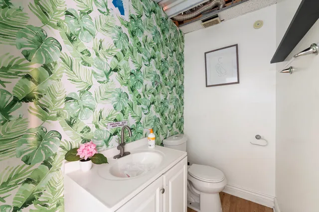 a bathroom with a sink and mirror with toilet
