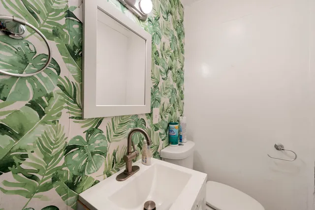 a bathroom with a sink and mirror with toilet