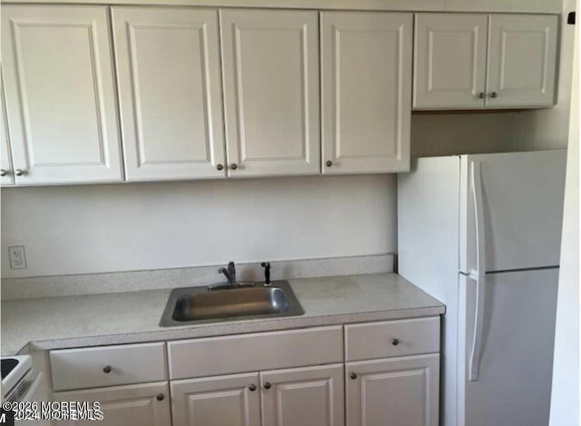 711 Wall Road, Unit 14 Spring Lake Heights, NJ 07762 - Photo 4 of 8 a kitchen with white cabinets and a refrigerator