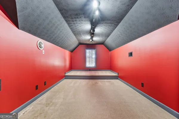 an empty room with windows and chandelier fan