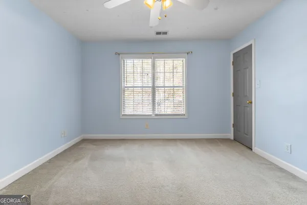 en empty room with window and chandelier fan