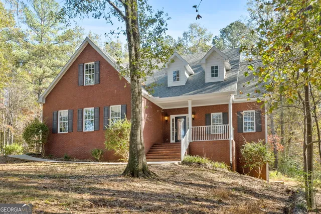 a front view of a house with trees and plants