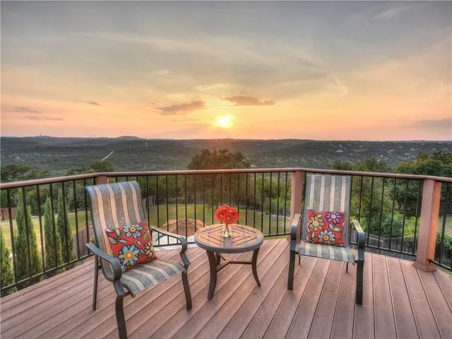 a balcony with wooden floor table and chairs