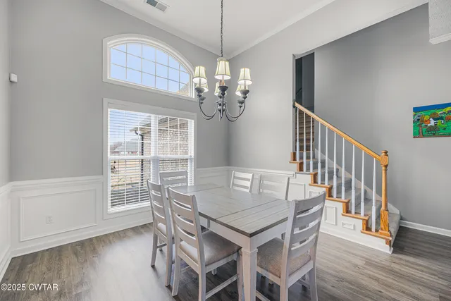 a view of a dining room with furniture wooden floor and chandelier
