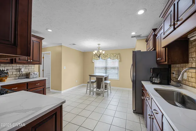a kitchen with granite countertop a sink appliances and cabinets