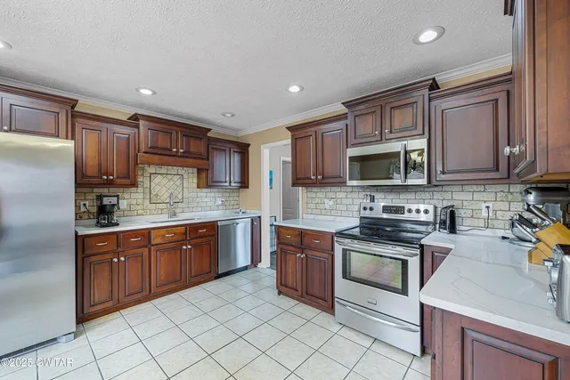 a kitchen with stainless steel appliances granite countertop a stove sink microwave and cabinets