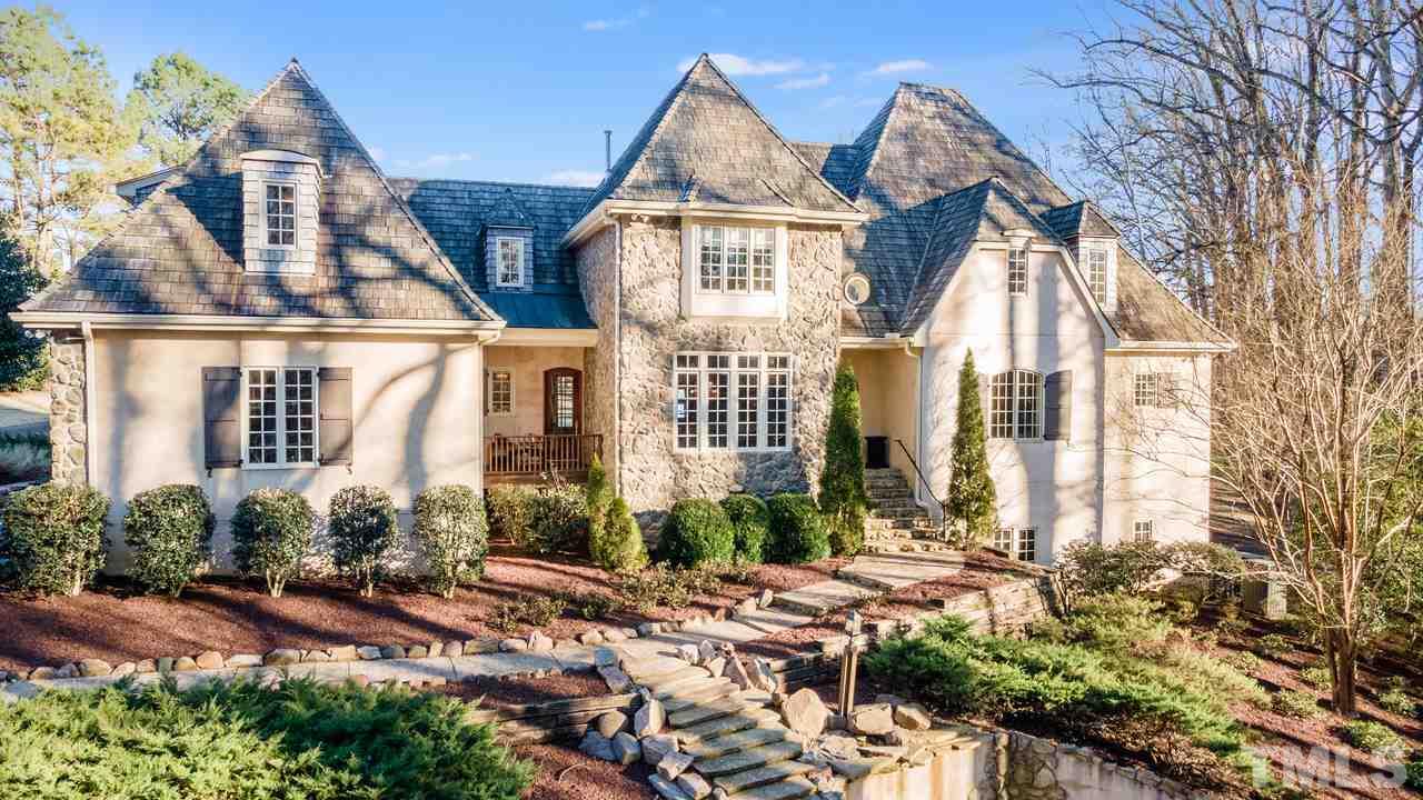 a view of a brick house with many windows next to a yard