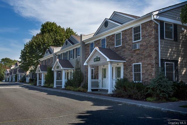 184 Hallock Road, Unit 1A1 Lake Grove, NY 11755 - Photo 3 of 3 a front view of a house with a yard and garage
