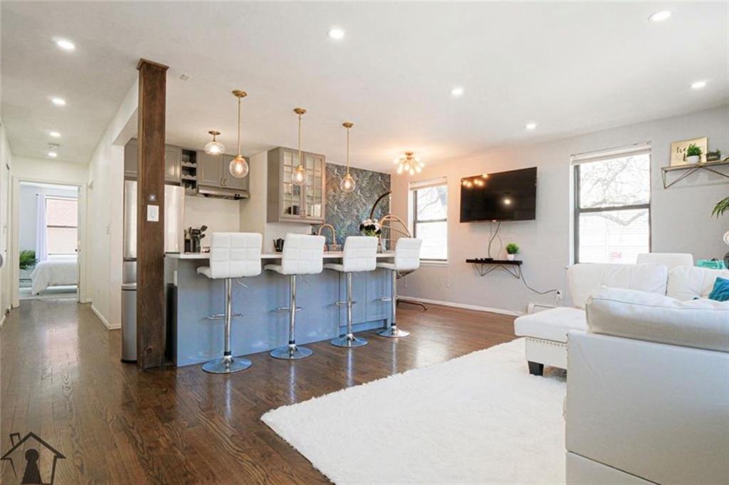 a living room with stainless steel appliances furniture and a view of kitchen