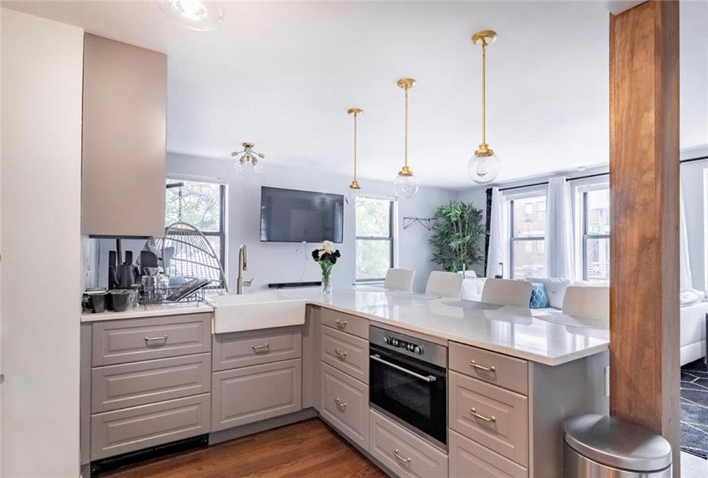54 Erasmus Street, Unit 2D Brooklyn, NY 11226 - Photo 4 of 7 a kitchen with white cabinets and sink