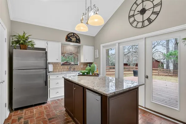 a kitchen with stainless steel appliances granite countertop a refrigerator and a stove top oven