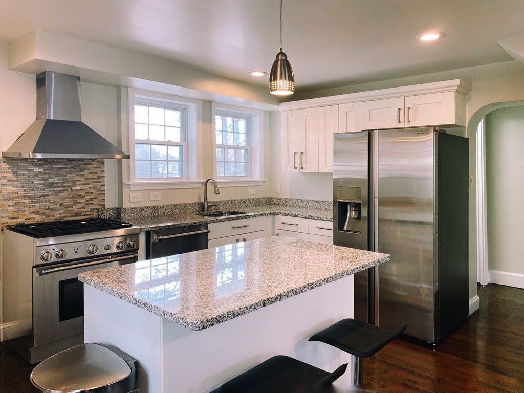 64 Royce Road Newton, MA 02459 - Photo 3 of 31 a kitchen with granite countertop a stove a refrigerator and a sink