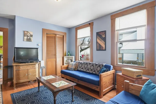 a living room with furniture a flat screen tv and a window