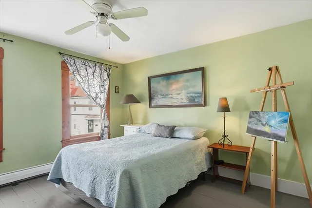 a bedroom with a bed a dresser and chair