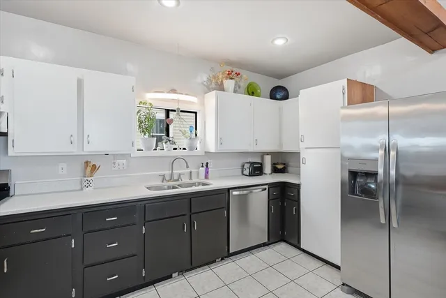 a kitchen with a sink a refrigerator and cabinets