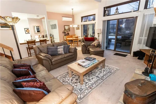 a living room with couches a coffee table and a dining table with wooden floor