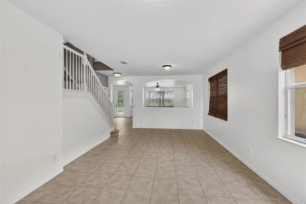 a view of empty room with wooden floor and ceiling fan