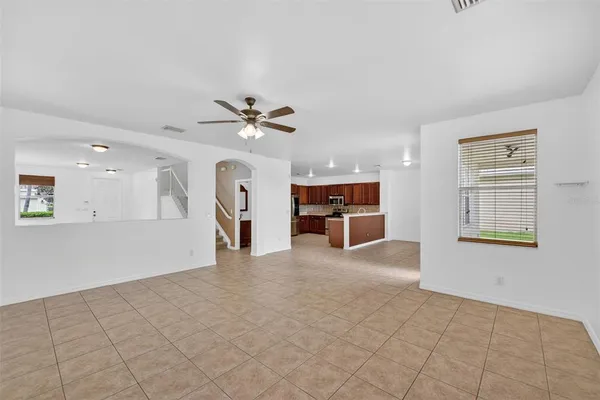 an empty room with a window and a fan