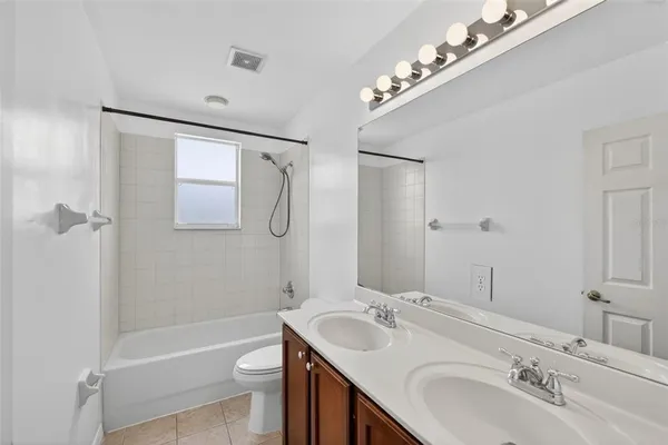a spacious bathroom with a tub sink and mirror