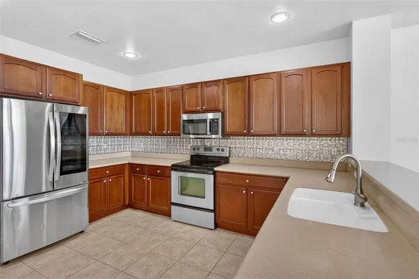 a kitchen with stainless steel appliances granite countertop a refrigerator and a sink