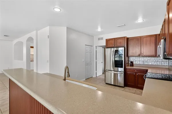 a large kitchen with a large counter top stainless steel appliances and cabinets