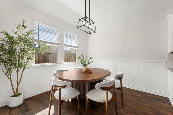 a dining room with furniture potted plants and wooden floor