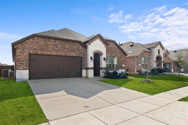 a front view of a house with a garden and yard