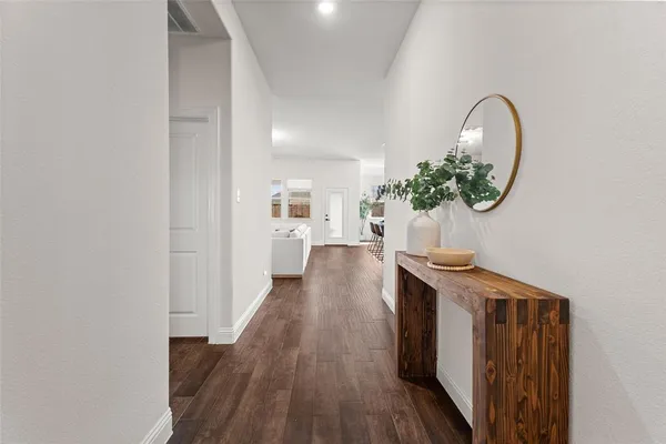 a view of a hallway with wooden floor and a potted plant